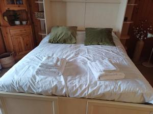 a bed with two towels and two pillows on it at Studio Le Cocon in Champéry
