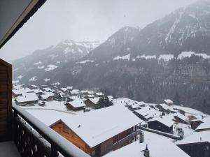 a town covered in snow in front of a mountain at Studio Le Cocon in Champéry
