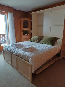 a bedroom with a large bed with a large headboard at Studio Le Cocon in Champéry