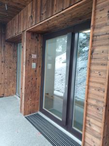 a building with glass doors and wood walls at Studio Le Cocon in Champéry