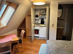 a small kitchen and dining room with a table and a room at Ferienwohnung Raabenhorst in Oettingen in Bayern