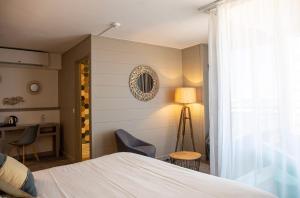a bedroom with a bed and a table and chairs at Hotel Port Marine in Sète