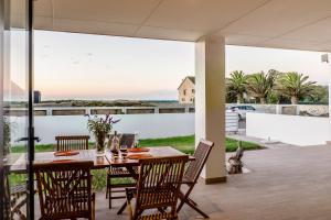 a table and chairs on a patio with a view of the ocean at Sea Spray Self Catering in Duyker Eiland in Britannia Bay