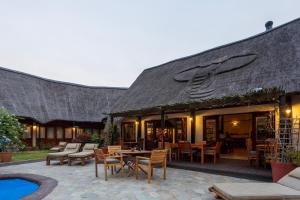 a building with a patio with tables and chairs at Elephants Footprint Lodge in Colchester