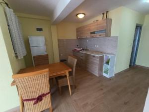 a kitchen and dining room with a wooden table at Martin apartman in Kruče