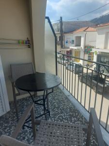 a table and chairs on a balcony with a view of a street at Karafelas rooms in Skiathos