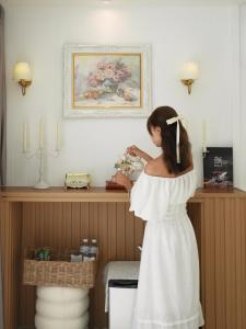 a woman in a white dress holding a bunch of flowers at Erawan Mountain Beach & Maya Erawan & Goodview Erawan in Tha Kradan