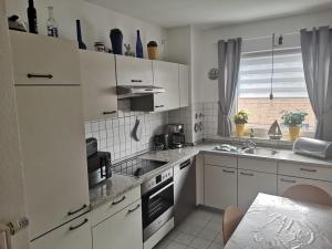a kitchen with white cabinets and a sink at Wohnung Jolmes in Dahme