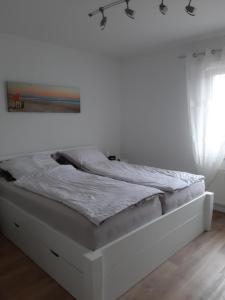 a bed in a room with a white wall at Wohnung Jolmes in Dahme