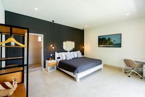 a bedroom with a bed and a black wall at Luxury 5BR Villa with Rooftop BBQ Pool 500M to Beach in Canggu +65 photos