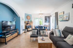 a living room with a couch and a tv at Villa Les Moreres de Sitges in Sitges