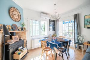 a dining room with a table and chairs and a clock at Villa Les Moreres de Sitges in Sitges