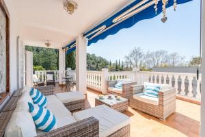 a patio with wicker furniture on a porch at Villa Les Moreres de Sitges in Sitges