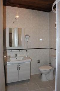 a bathroom with a sink and a toilet and a mirror at Oasis Pansiyon in Edirne