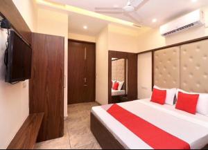 a bedroom with a bed and a flat screen tv at Jeevak hotel in Mohali