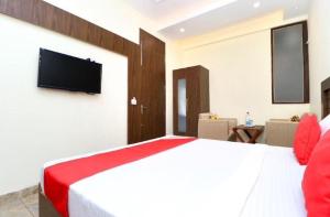 a bedroom with a large bed with a television on the wall at Jeevak hotel in Mohali +9 photos