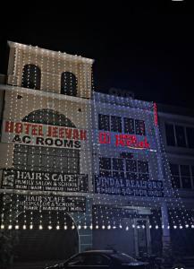 a building covered in christmas lights at night at Jeevak hotel in Mohali