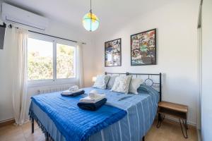 a bedroom with a blue bed with towels on it at Villa Les Moreres de Sitges in Sitges +28 photos