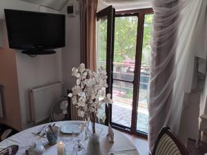 a dining room table with a vase of flowers on it at Iasskii Torg - La belle epoque in Iaşi