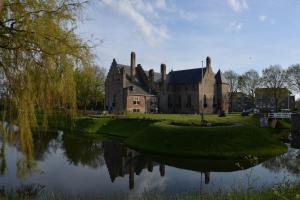 an old castle with a lake in front of it at Bungalow Ijsselmeer in Medemblik