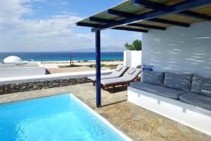 a villa with a swimming pool and a couch at Villa D - Kamari Village in Aliko Beach