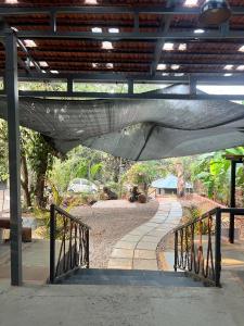 a hammock is hanging over a walkway at Artjuna CoLiving in Assagao