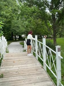 a woman is standing on a wooden bridge at Casa Tabacon CR USA in Trenton