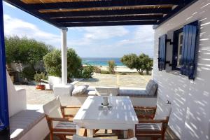 a patio with a table and chairs and the ocean at Villa D - Kamari Village in Aliko Beach