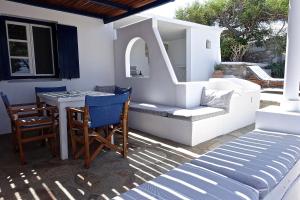 a patio with a table and chairs and a table and a table and chairs at Villa D - Kamari Village in Aliko Beach