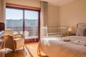 a bedroom with a bed and a large window at Spacious Seafront Residence - Family Friendly in Vila Nova de Gaia +78 photos