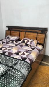 a bedroom with a bed with a checkered blanket at Thakur Shri Dwarkadhish Seva Sadan in Mathura