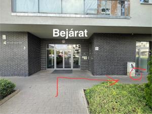 a building with a sign that reads be patient at Kis kertes lakás in Pusztavacs