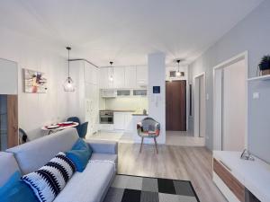 a living room with a couch and a kitchen at Kis kertes lakás in Pusztavacs