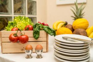 a table with plates and a box of fruits and vegetables at MH Hotel Maracaibo in Rimini
