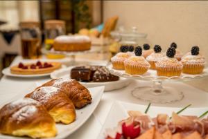 a table topped with plates of pastries and cakes at MH Hotel Maracaibo in Rimini
