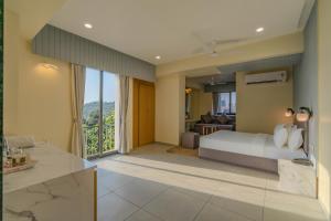 a bedroom with a bed and a living room at hotel mon ville alkapuri in Vadodara