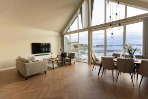 a living room with a dining table and a large window at Panorama Rorbusuiter in Steinsland