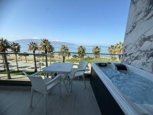 a hot tub on a balcony with a table and chairs at Jimi Apartments in Vlorë