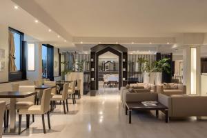a lobby with tables and couches and tables and chairs at Golf Hotel Milano in Opera