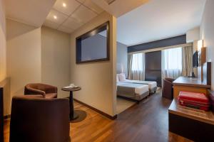 a hotel room with a bedroom with a bed and a chair at Golf Hotel Milano in Opera +64 photos