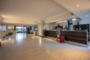 a man and a woman standing at a counter in an airport at Golf Hotel Milano in Opera