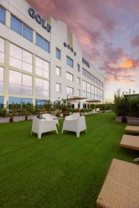 a building with benches in the grass in front of it at Golf Hotel Milano in Opera