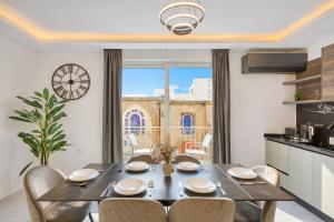 a kitchen and dining room with a table and chairs at The Bellview Suite - Luxury 1 BR APT - Central Gzira in Il-Gżira