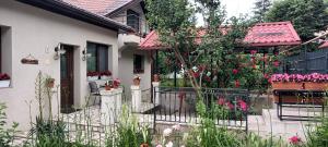 a white house with a fence and flowers at Iasskii Torg - La belle epoque in Iaşi
