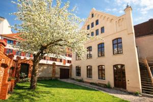 a tree in a yard next to a building at Hotel Denkmal 13 Wismar in Wismar