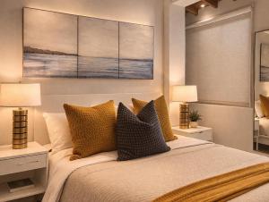 a bedroom with a bed with pillows and two lamps at Mackenzie Beachfront Panorama in Larnaca