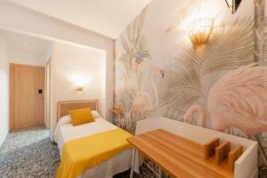 a hotel room with two beds and a table at Hotel BH Los Ángeles in Benidorm