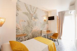 a hotel room with a bed and a mural of pink flamingos at Hotel BH Los Ángeles in Benidorm