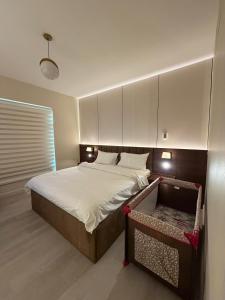 a bedroom with a large bed with white sheets at شقة البيلسان فيو Baylasun View in King Abdullah Economic City +22 photos