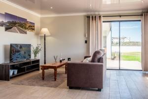 a living room with a couch and a table at Sea Spray Self Catering in Duyker Eiland in Britannia Bay